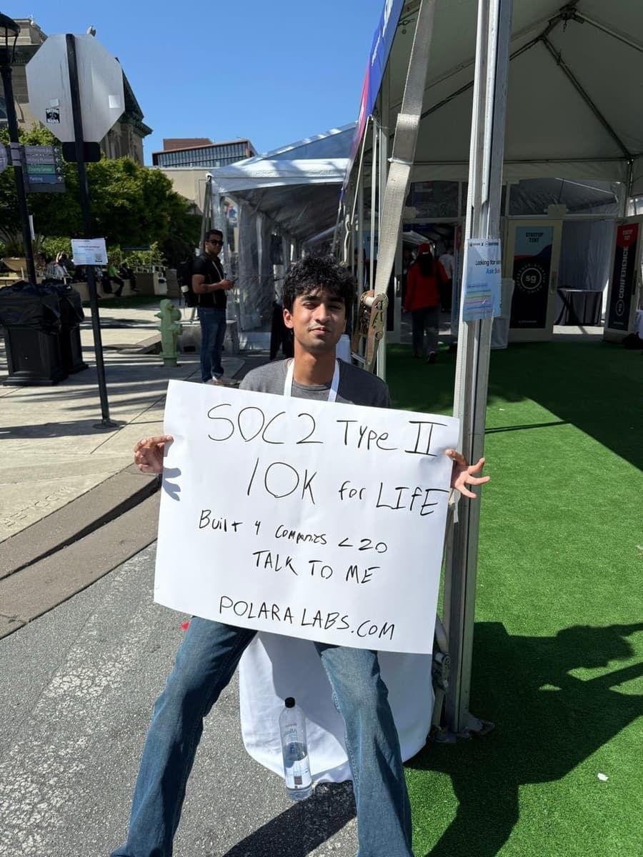 me holding a hand lettered polara labs sign outside the startup grind tents